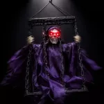 Lógó, láncos kalitkába zárt, LED-es hangot adó animált Halloween-dekoráció csontváz